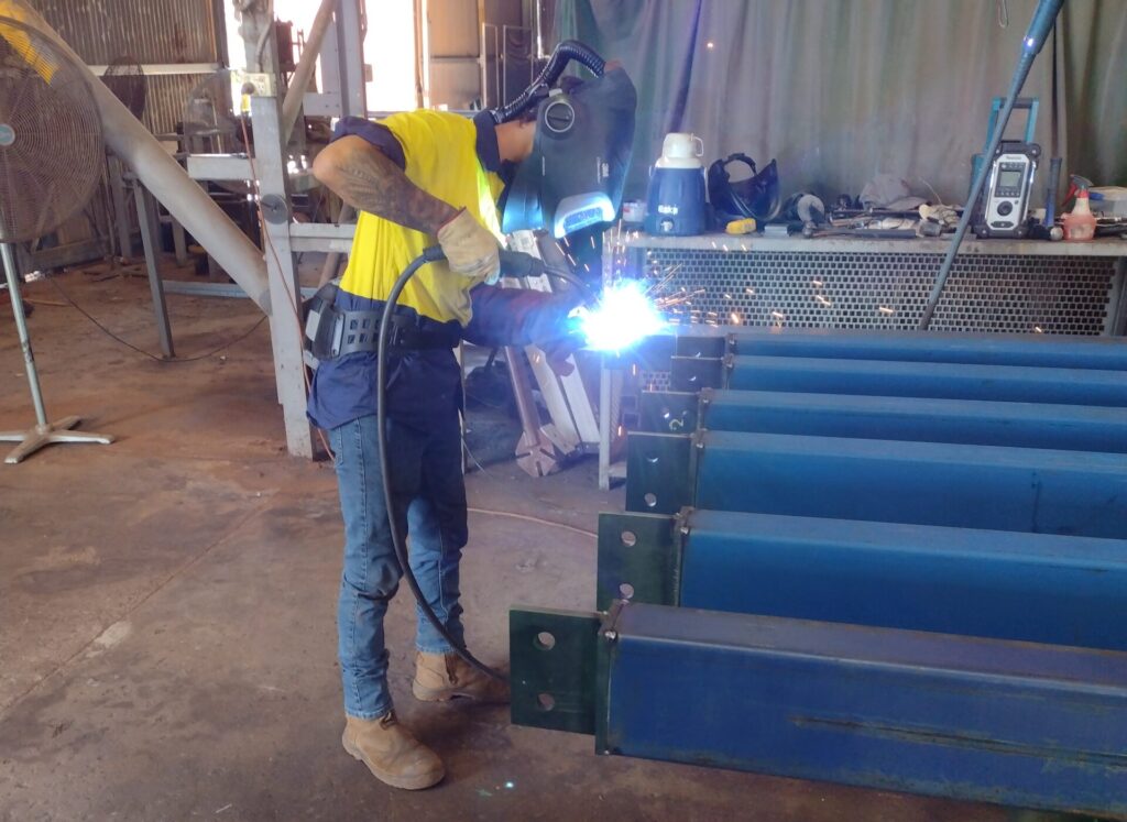 Shows Tyson welding a steel beam
