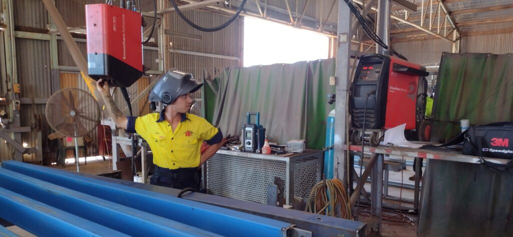 Tyson switching on the welding equipment in the KMPL workshop